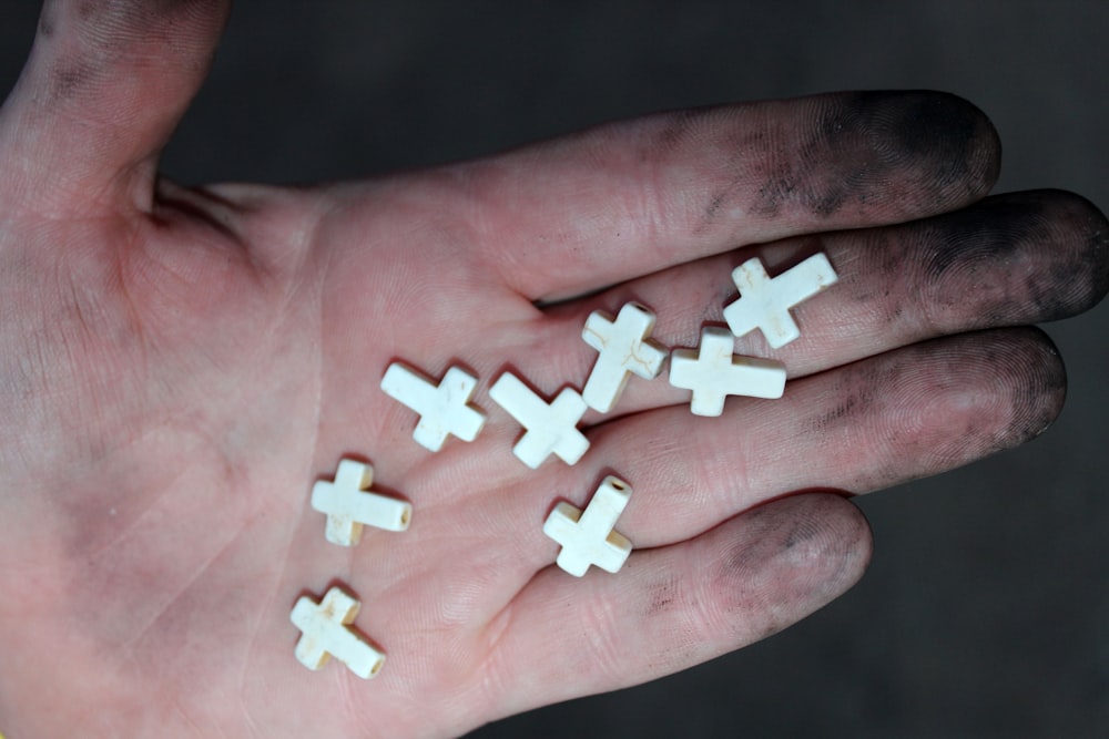 person holding 4 white cross