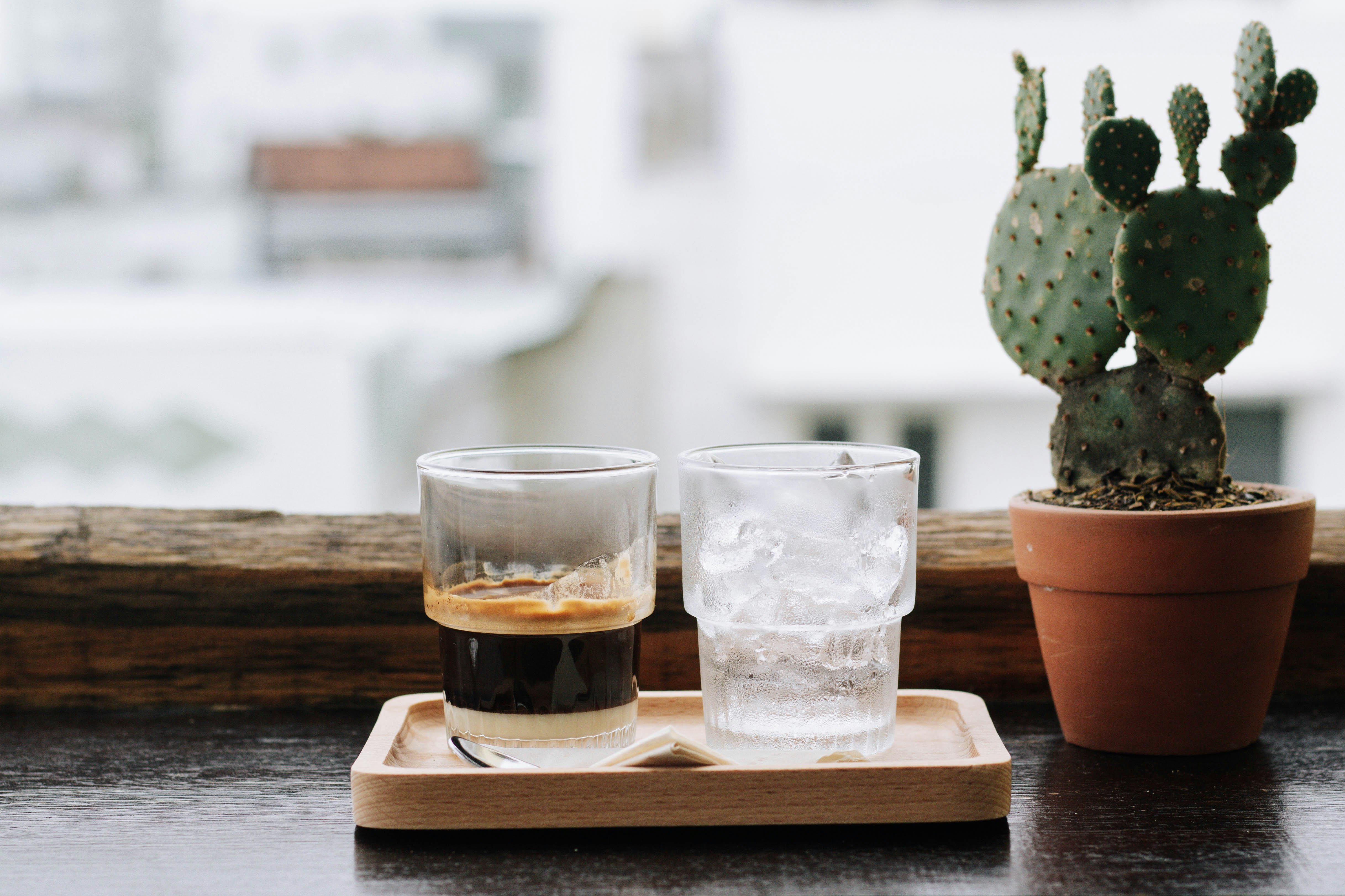 three clear drinking glasses on brown wooden tray