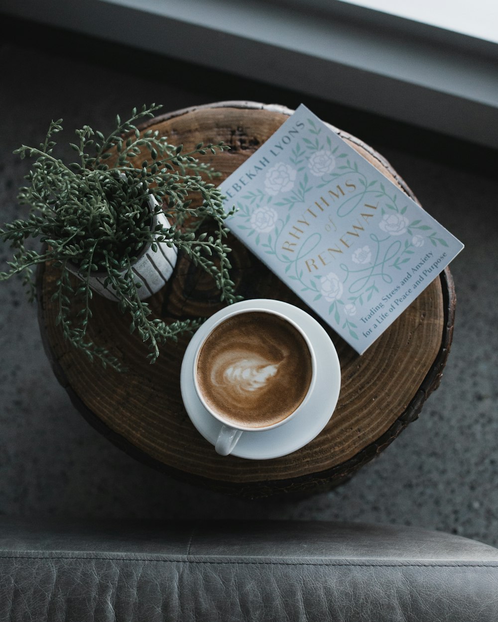 white ceramic mug with brown liquid inside on brown wooden round tray