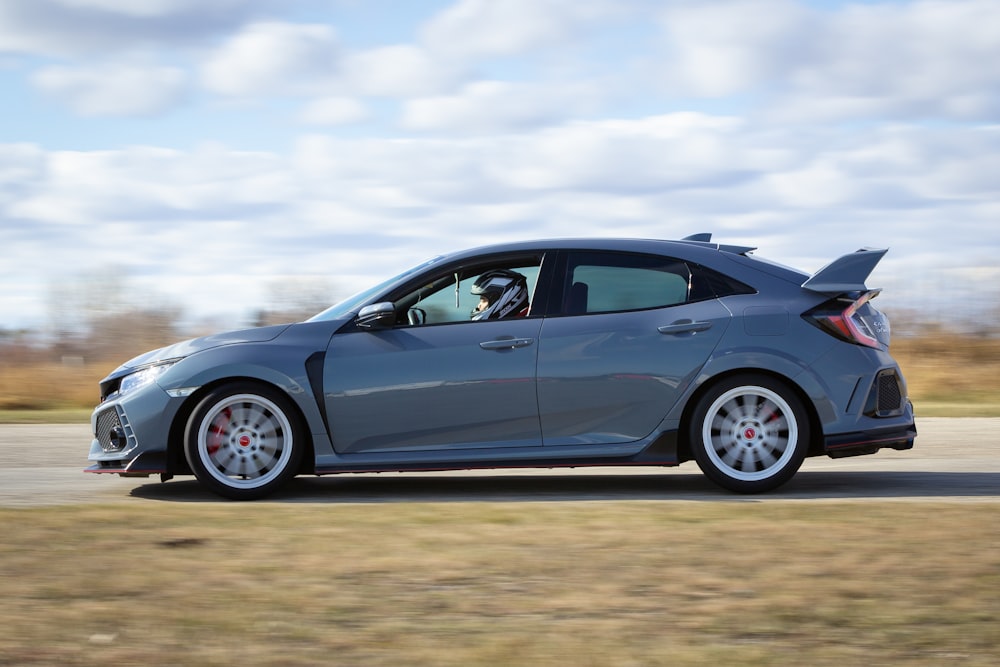 black coupe on brown field under white clouds during daytime