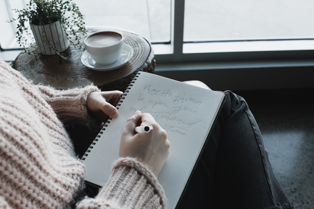 person writing on white paper