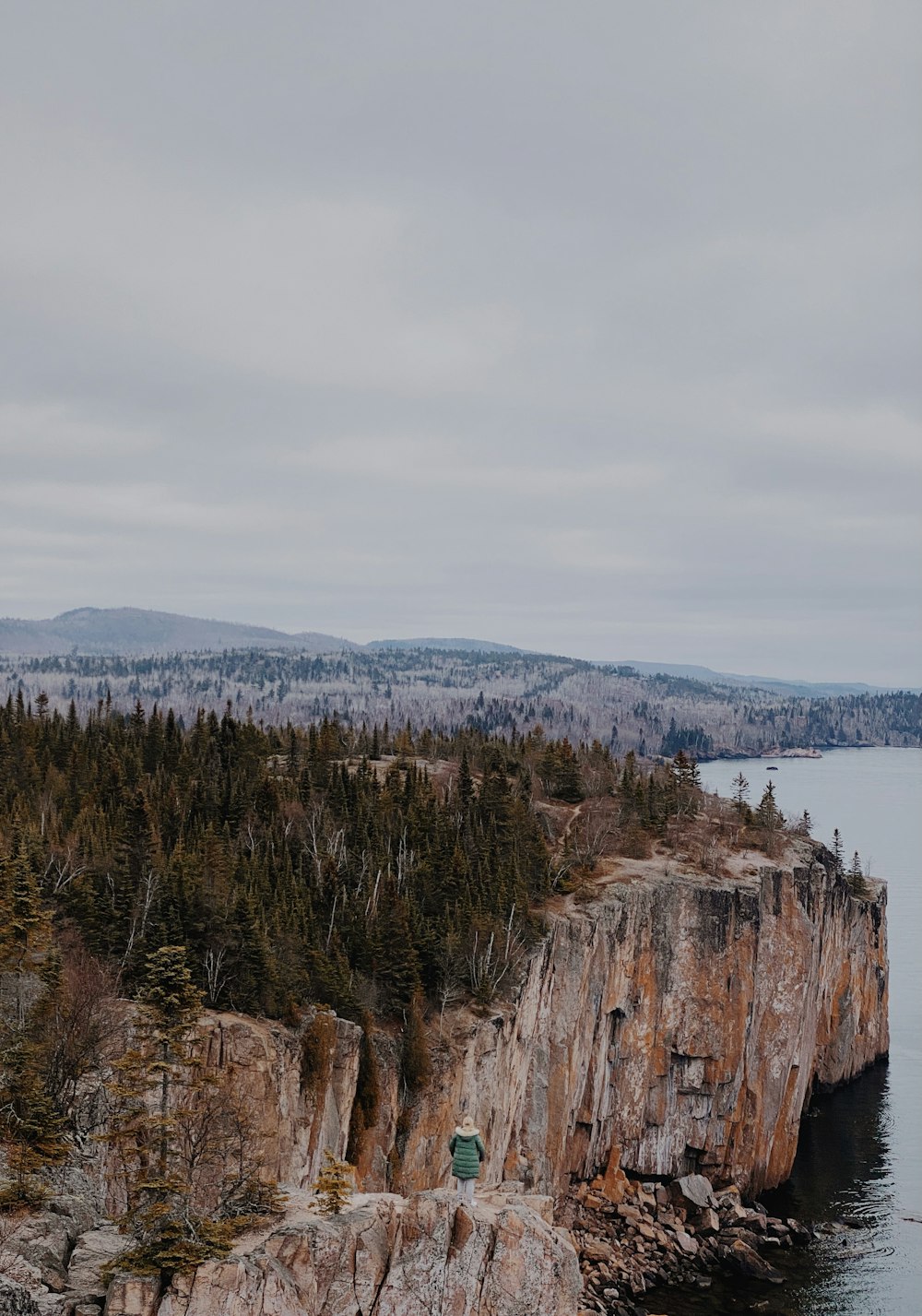 brown rocky mountain near body of water during daytime