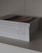 A stack of neatly arranged religious books with white covers displayed on a shelf, each titled with a different book of the Bible.