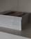 A stack of neatly arranged religious books with white covers displayed on a shelf, each titled with a different book of the Bible.