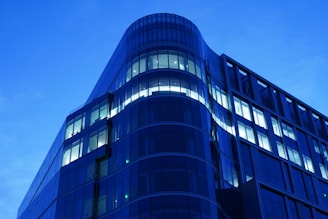 Abstract modern architecture with clean lines and blue-magenta lighting reflecting technological innovation.