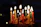 A colorful birthday cake with candles lit, surrounded by joyful party guests.