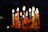 A colorful birthday cake with candles lit, surrounded by joyful party guests.