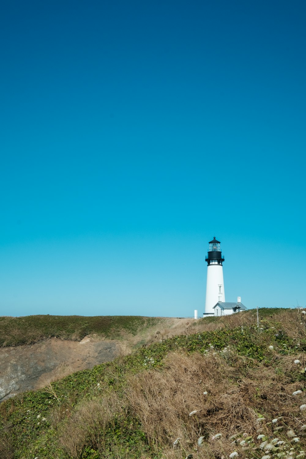 white and black lighthouse under blue sky during daytime