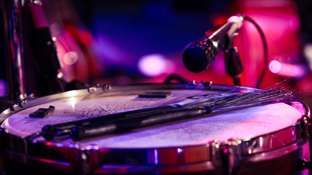 black and silver microphone on black and white drum set