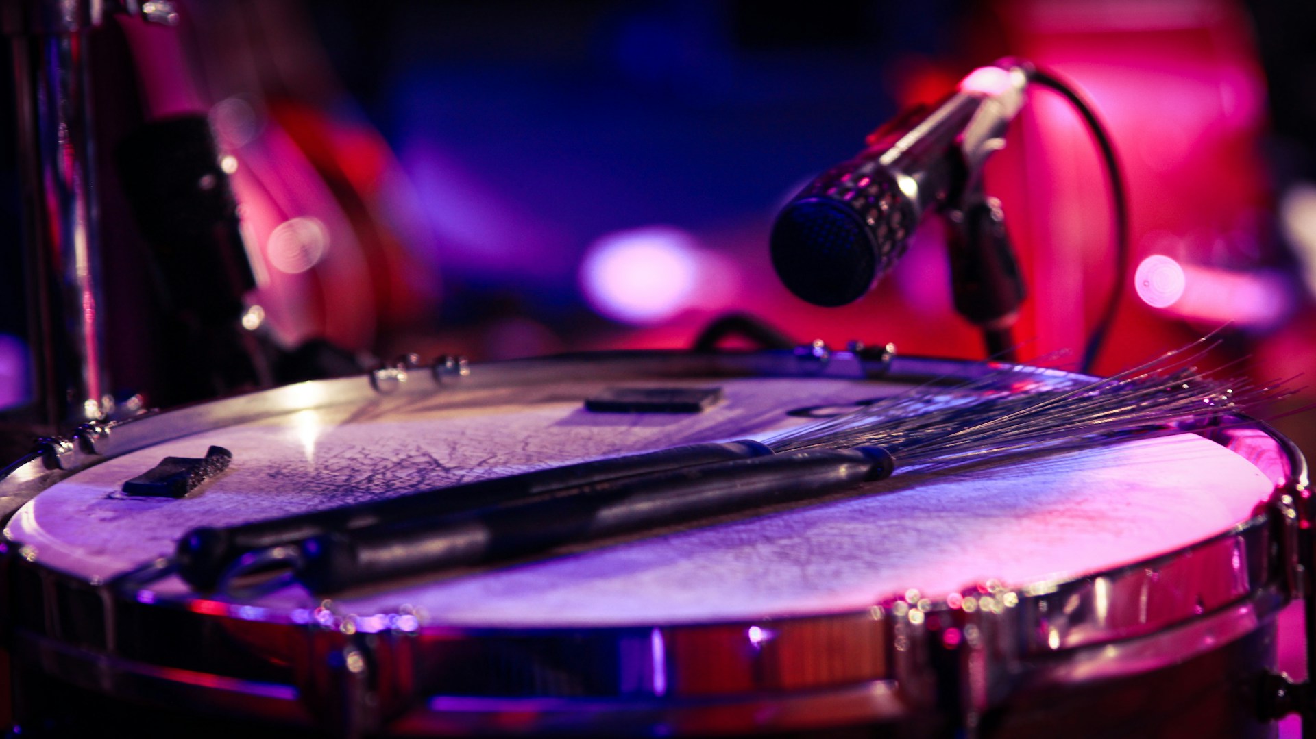 black and silver microphone on black and white drum set
