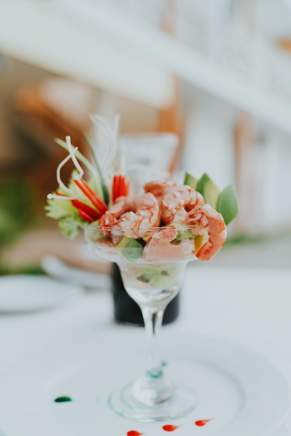 orange and white flower bouquet on clear glass footed cup