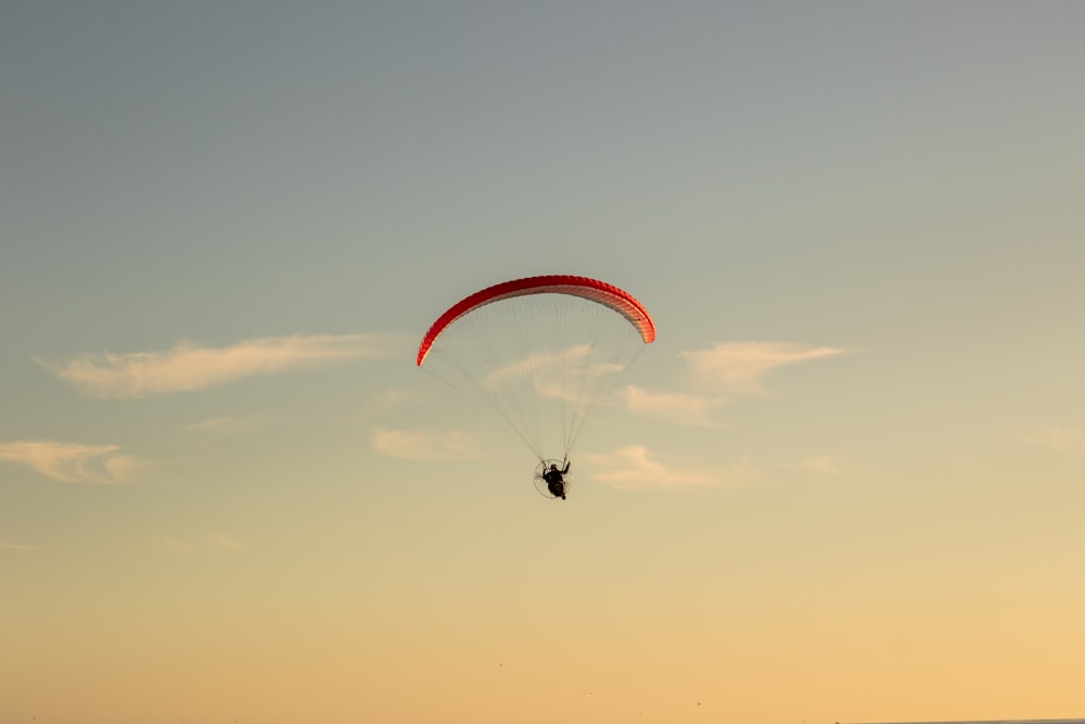 person in parachute under blue sky during daytime