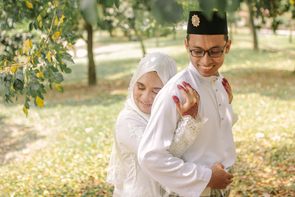 A warm, inviting photo of a diverse Muslim couple sharing a joyful moment outdoors.