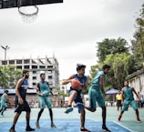 Adults competing fiercely in a summer basketball league game.