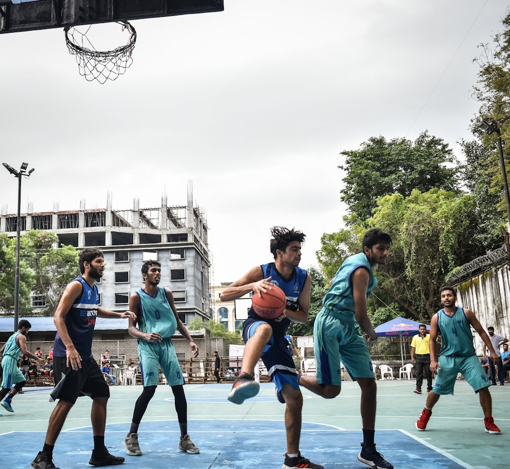 Foto Grupo de pessoas jogando basquete durante o dia – Imagem de