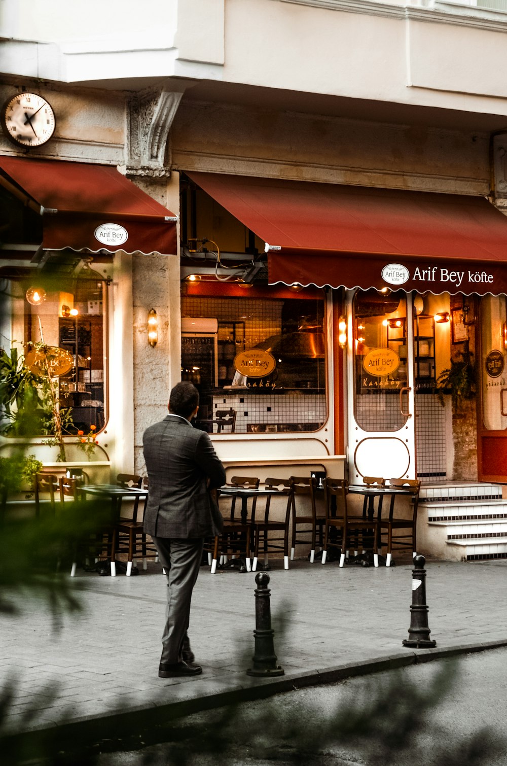 man in black jacket sitting on brown wooden chair