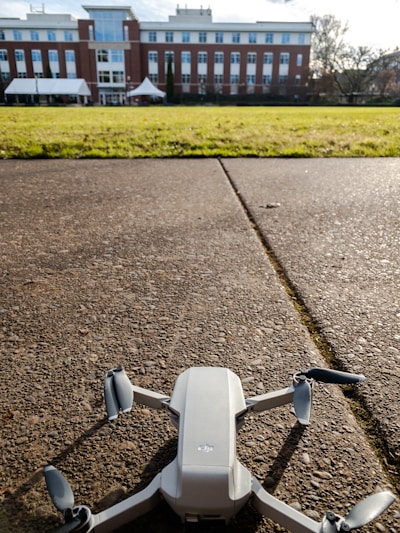 A professional technician using a drone to photograph a residential building's rooftop for energy performance analysis.