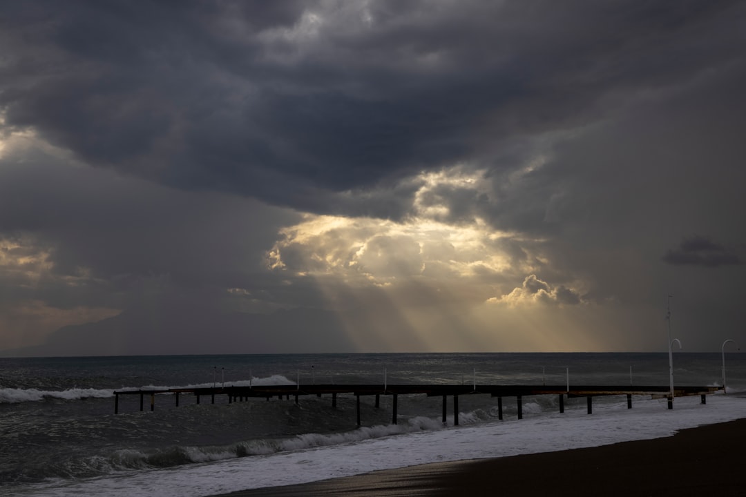 brown wooden dock on sea under cloudy sky during daytime