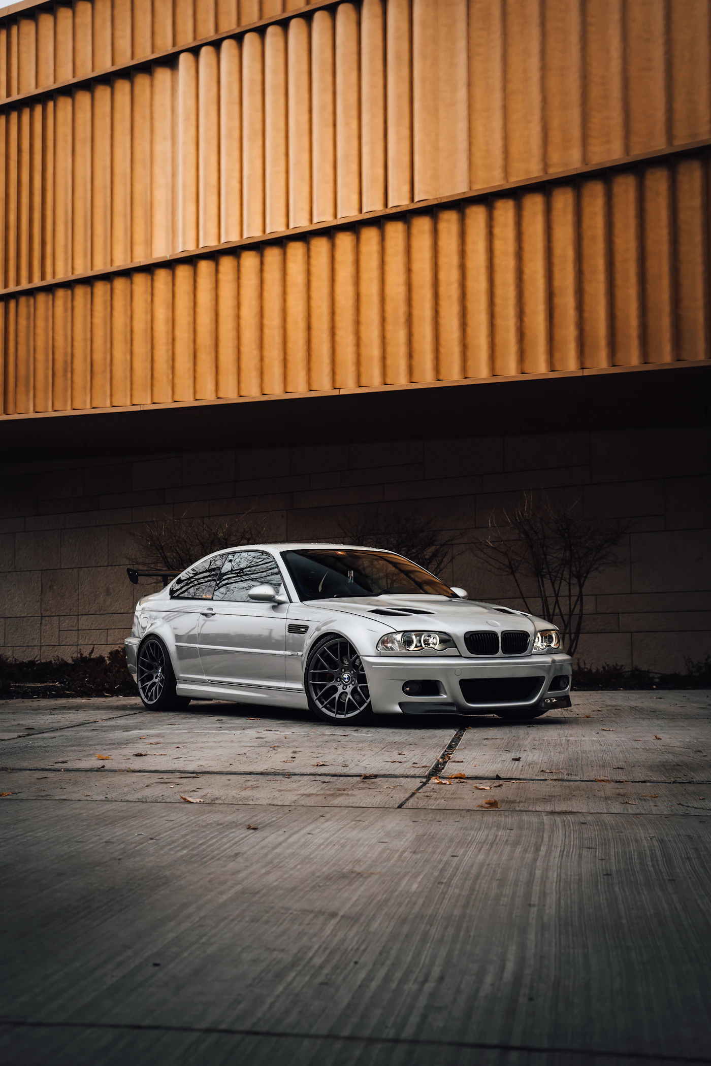 White BMW coupe parked beside an orange wall