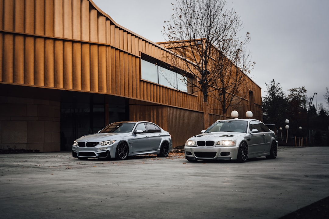 white sedan parked beside brown building