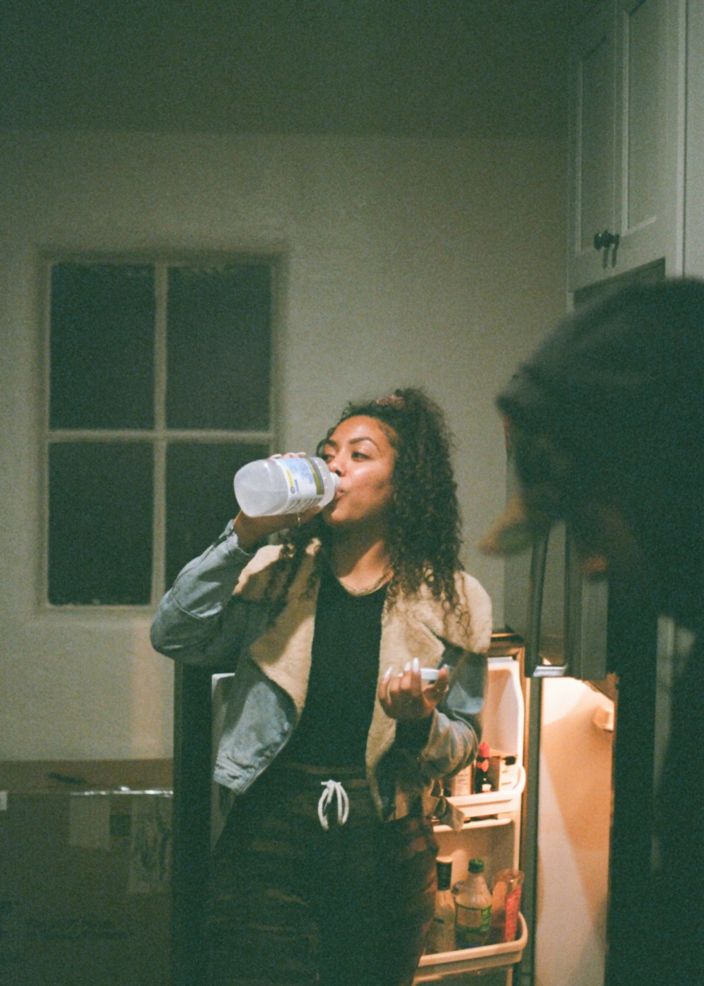 woman in black tank top drinking from bottle