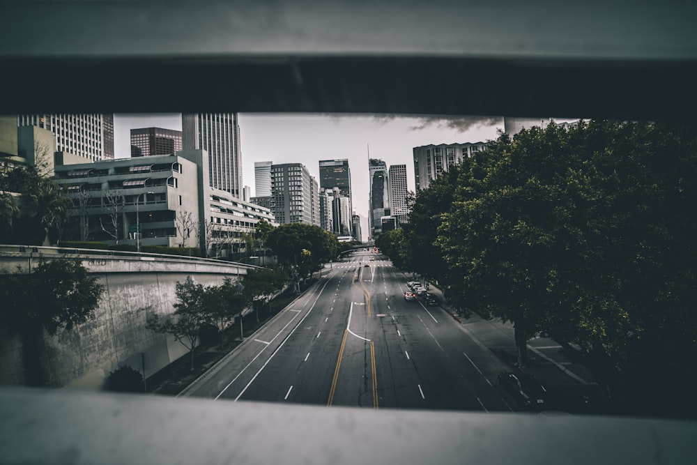 black asphalt road in between of high rise buildings during daytime