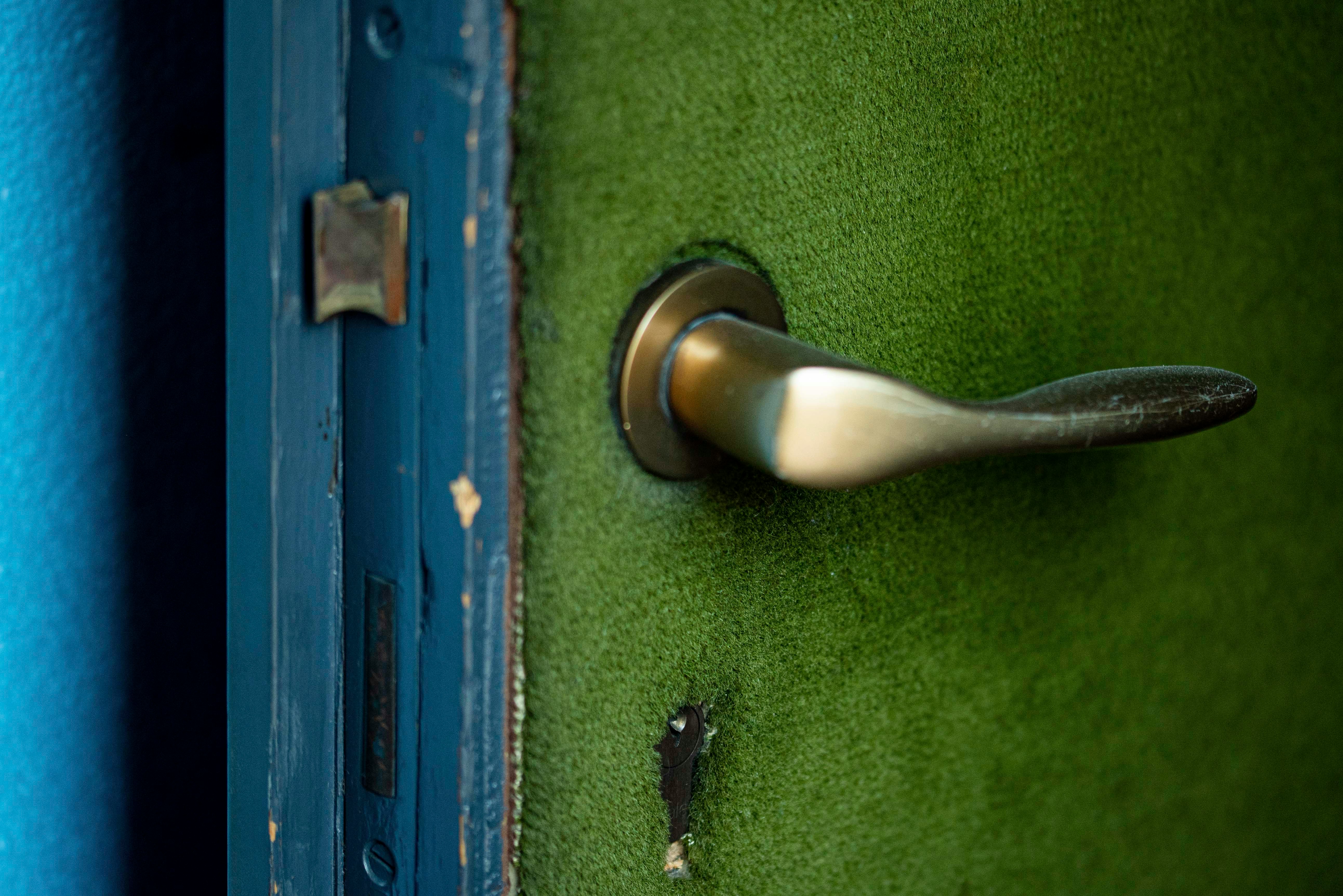 silver door lever on green wooden door