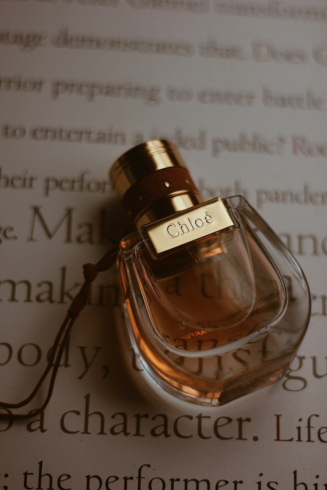 clear glass perfume bottle on white paper