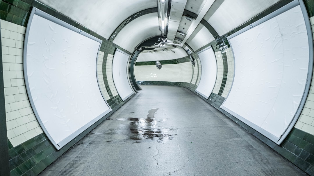 grayscale photo of tunnel with light,