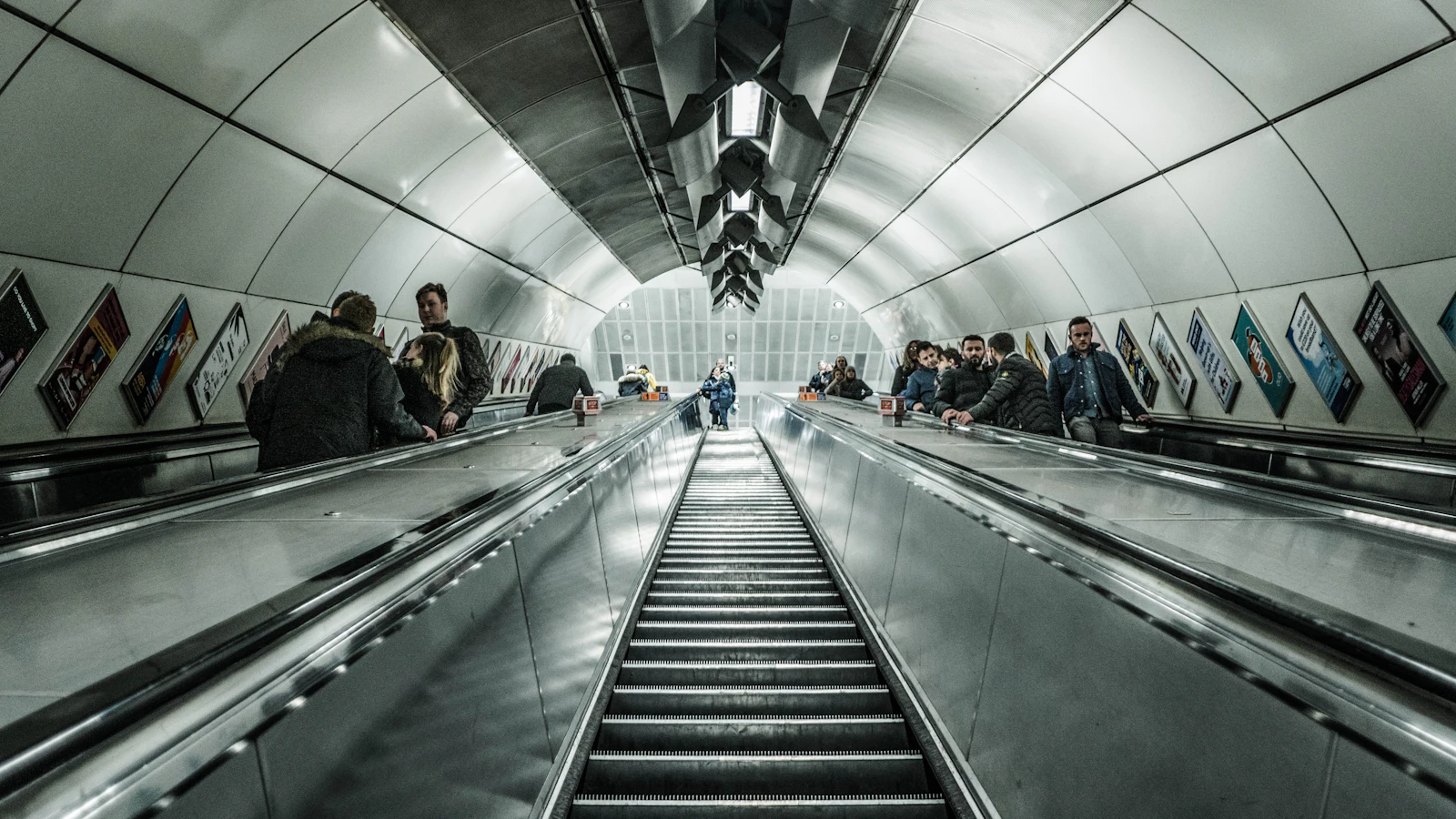 Passengers on a long escalator in a London Underground station
