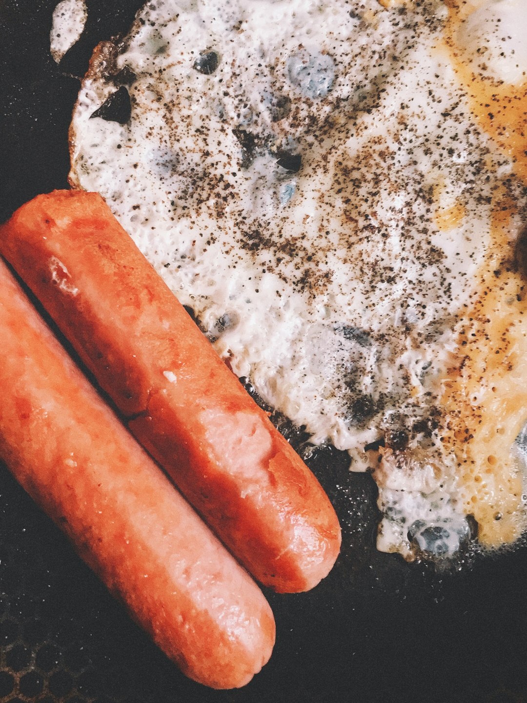 sausage on black pan with white powder