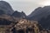 A person standing on a mountain peak, looking at a vast landscape, symbolizing achievement.