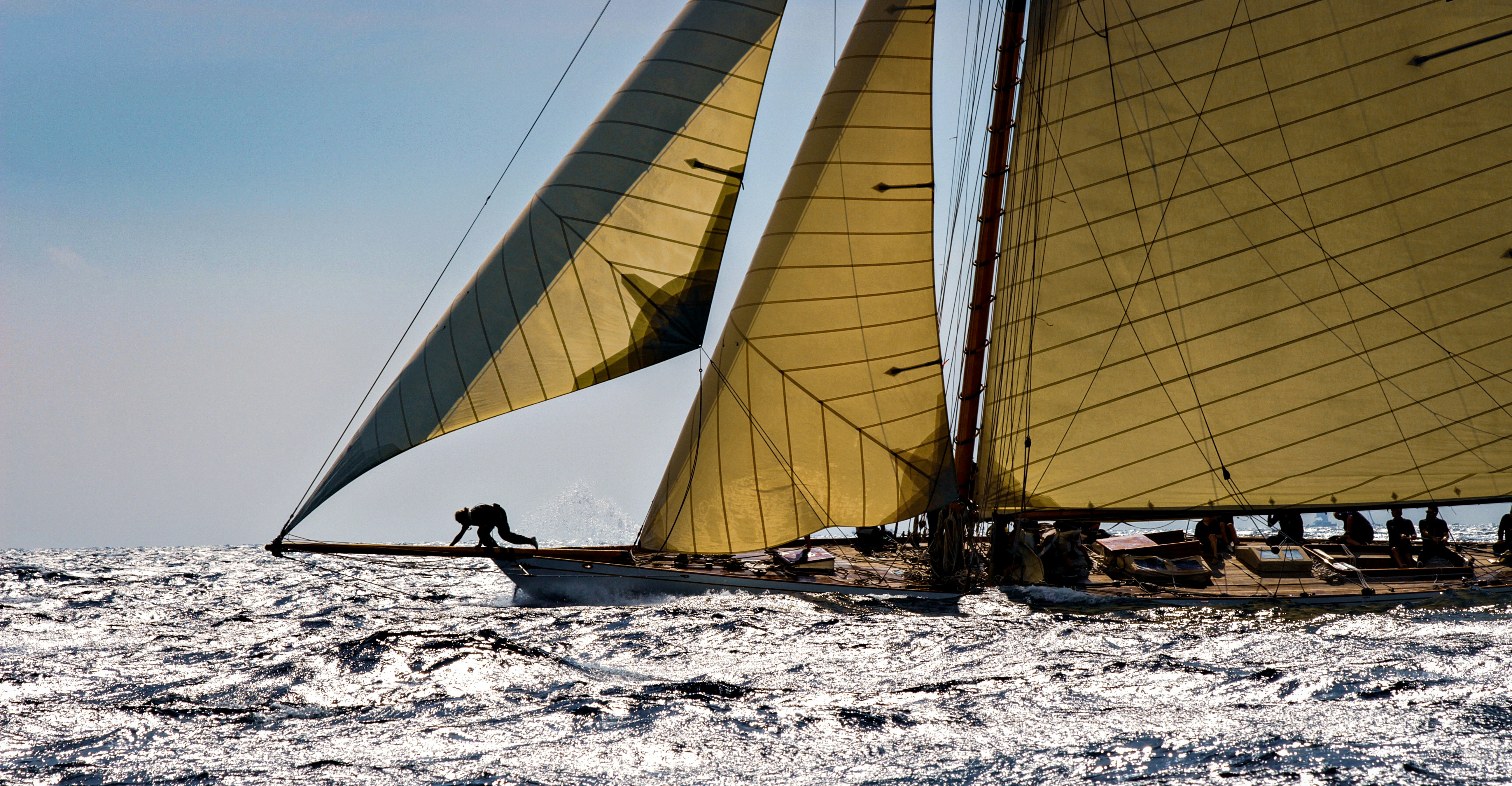 person in black shirt sitting on white sail boat during daytime, 