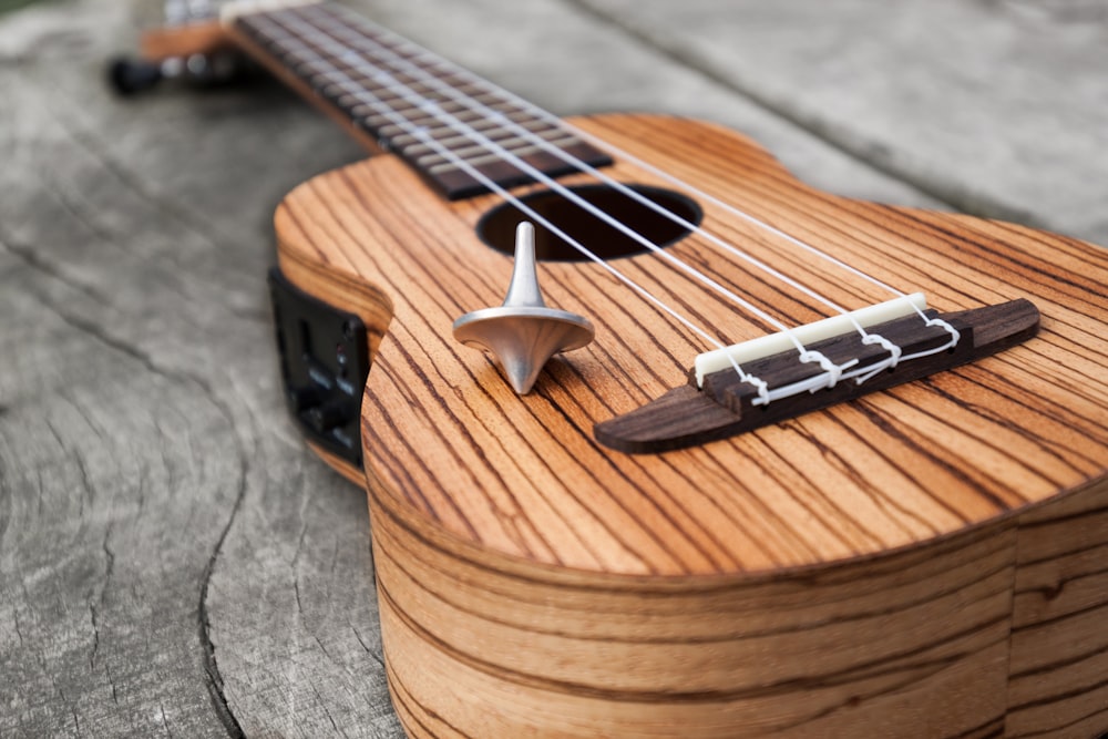 Guitarra acústica marrón sobre mesa de madera marrón