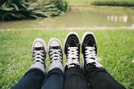 A pair of shoes next to outdoor gear on grass.