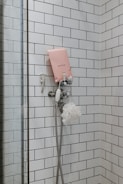 white shower head on white wall tiles