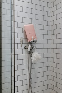 white shower head on white wall tiles