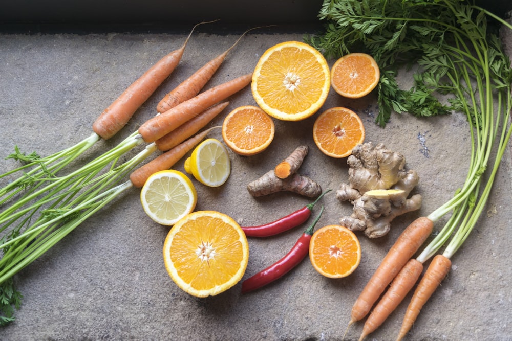 in Scheiben geschnittene Orangenfrüchte neben grünem und orangefarbenem Gemüse