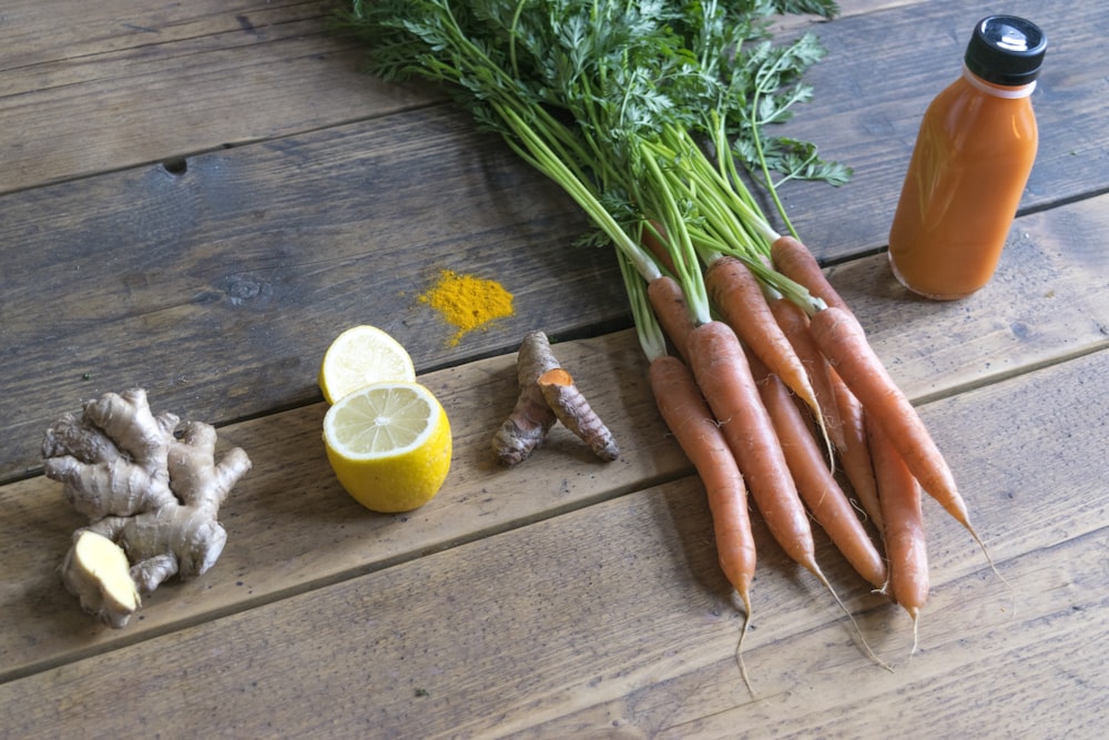 carrot and green vegetable on brown wooden table