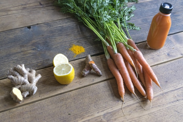 Carrot and green vegetable on brown wooden table