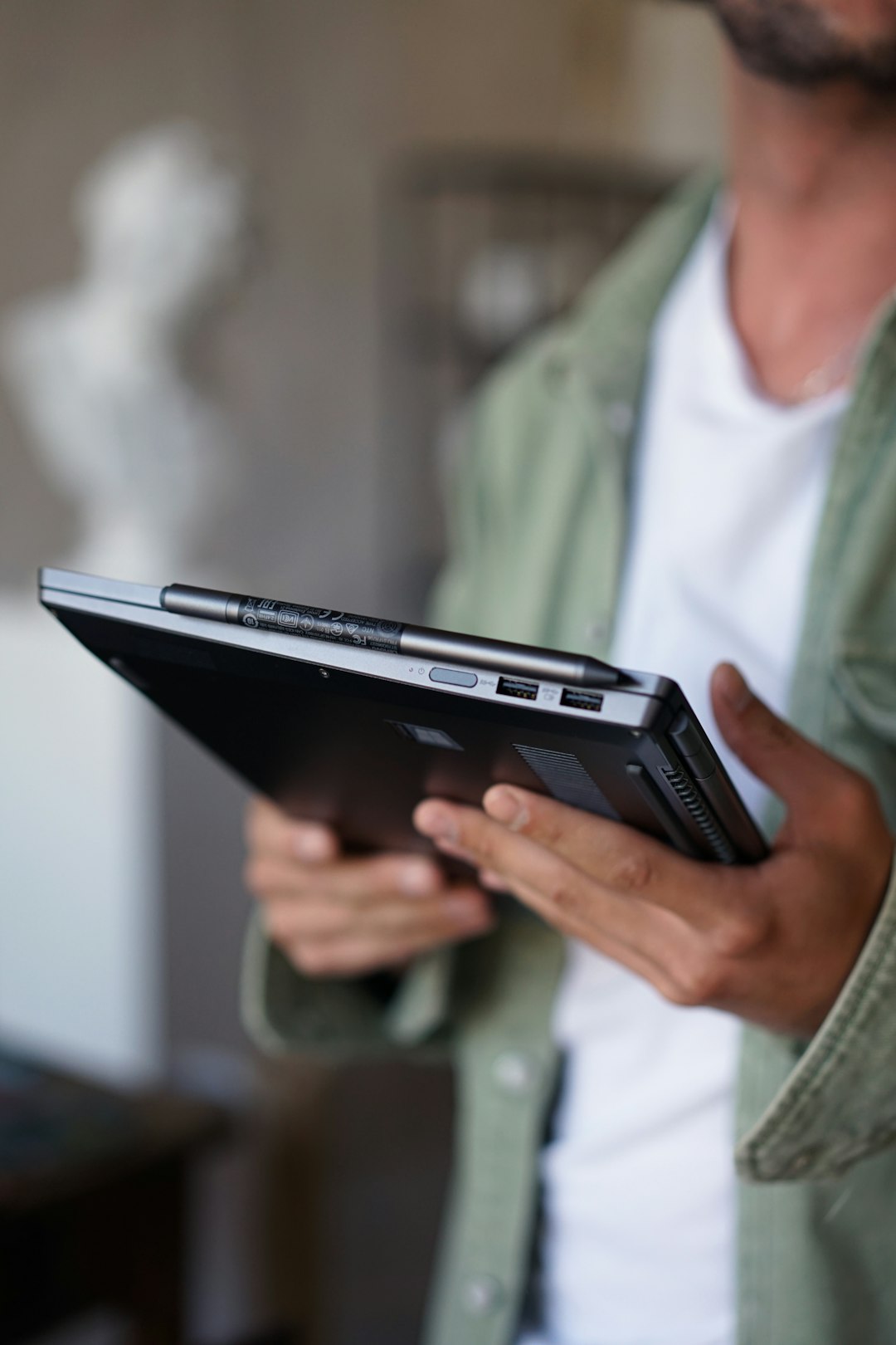 person in green shirt holding black electronic device