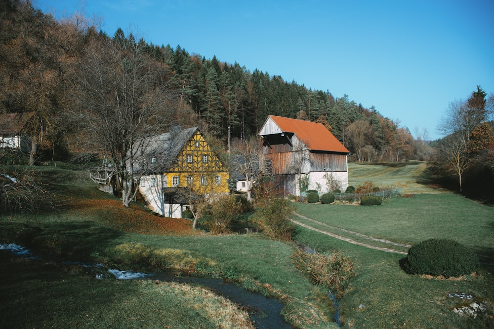 Maison brune et blanche près de Green Grass Field pendant la journée