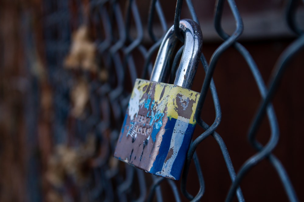 blue padlock on grey metal fence