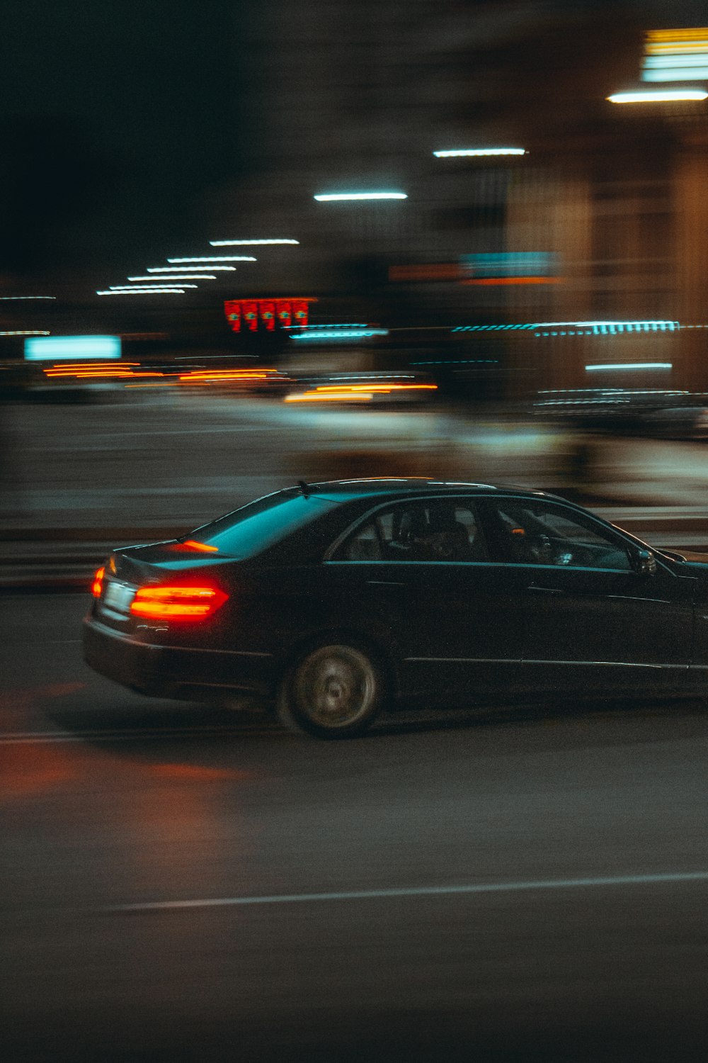 夜間の道路を走る黒いセダン