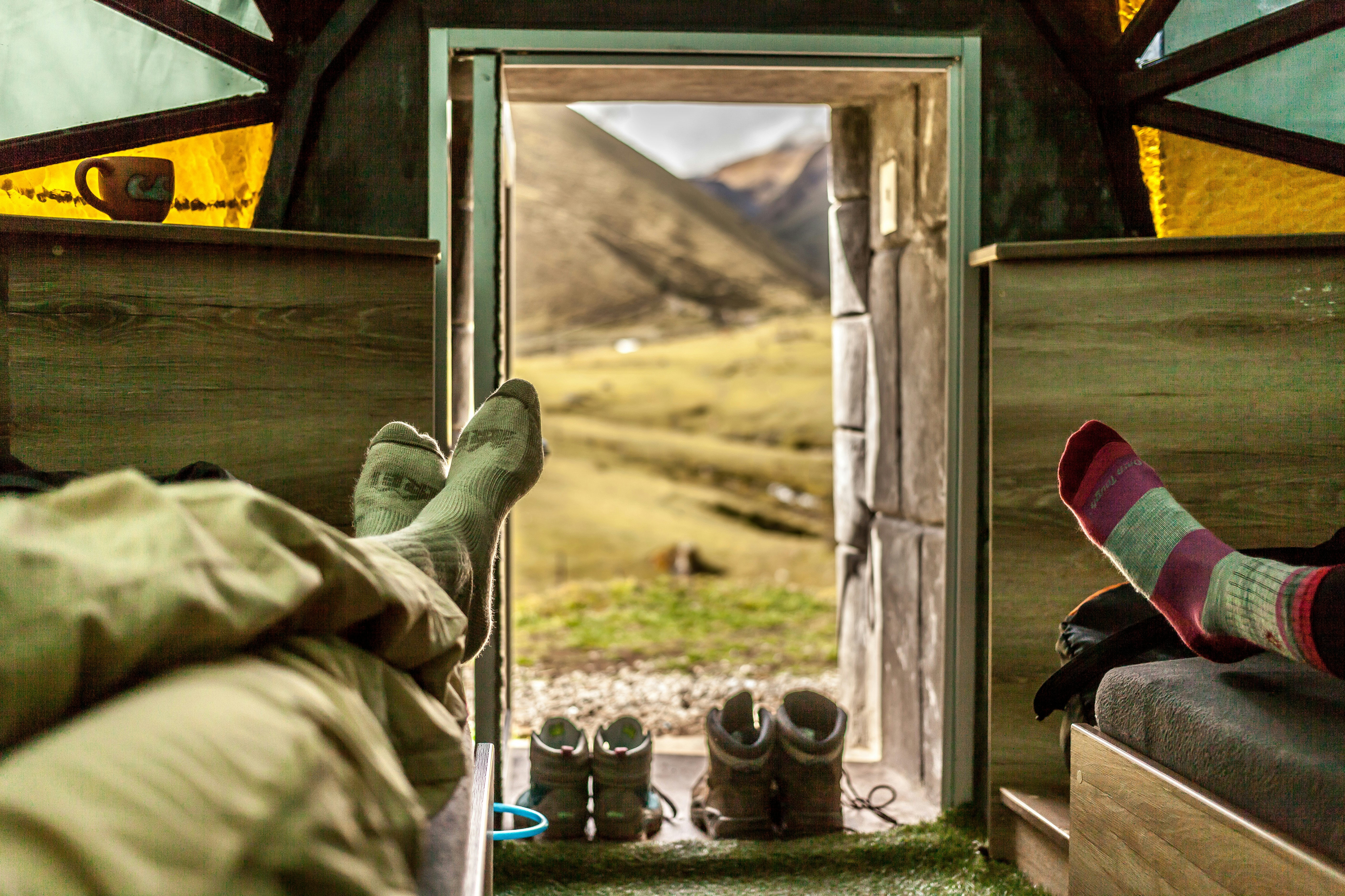 person in green pants and black leather boots sitting on chair