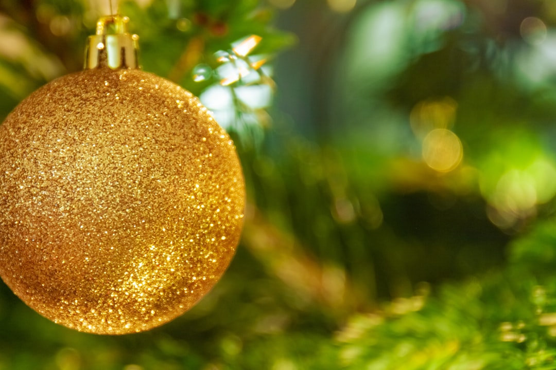 gold bauble hanged on green tree