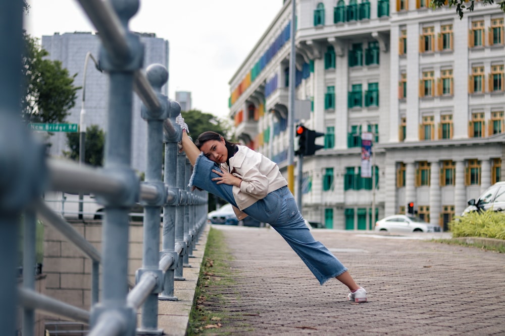 woman in white shirt and blue denim jeans running on gray concrete pathway during daytime