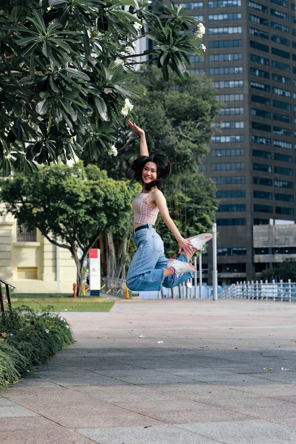 woman in blue denim jeans sitting on gray concrete bench during daytime