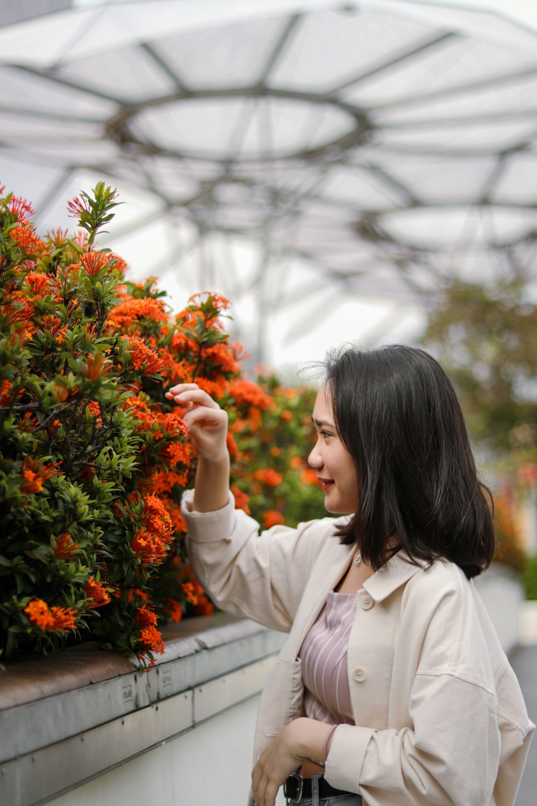 woman in white coat holding orange flowers