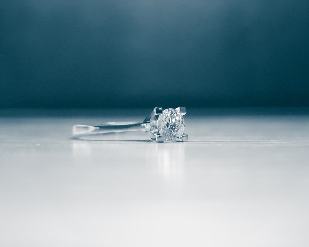 anello in argento su superficie bianca
